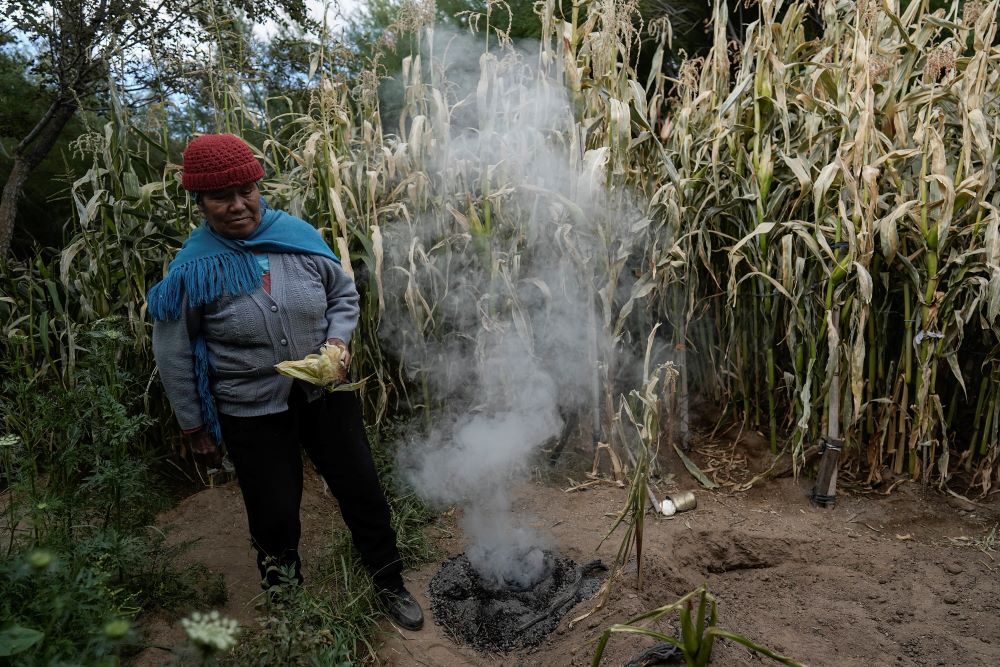 Irene Leonor Flores de Callata, 68, performs a brief ceremony to thank the Earth after inspecting her corn crop at her home in Tusaquillas, Jujuy Province, Argentina, on April 23, 2023.